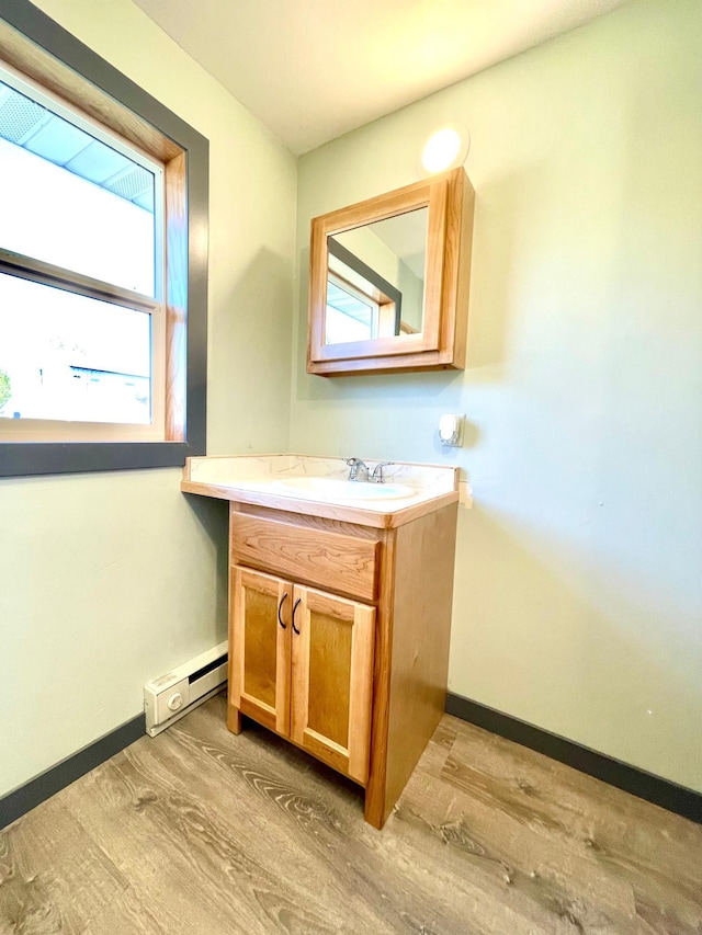 bathroom with vanity, a baseboard radiator, and hardwood / wood-style floors