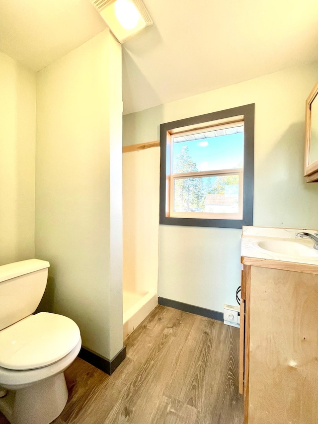 bathroom with vanity, toilet, a shower, and hardwood / wood-style floors