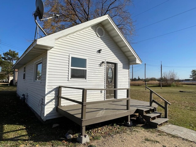 view of front of home with a wooden deck and a front lawn