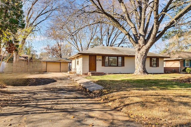 view of front of house featuring a garage, an outdoor structure, and a front lawn