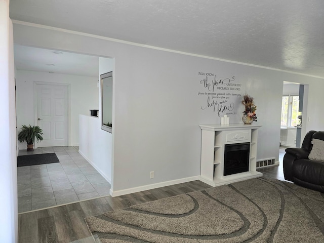 living room with ornamental molding, hardwood / wood-style floors, and a textured ceiling