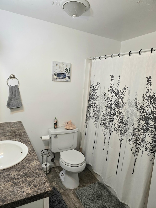 bathroom with vanity, toilet, a shower with curtain, and hardwood / wood-style floors