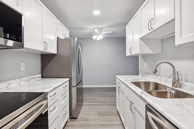 kitchen with white cabinets, stainless steel appliances, light hardwood / wood-style floors, and sink