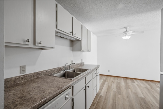 kitchen featuring sink, light wood-type flooring, a textured ceiling, white cabinetry, and ceiling fan