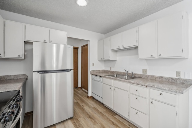 kitchen featuring appliances with stainless steel finishes, sink, a textured ceiling, light hardwood / wood-style floors, and white cabinets