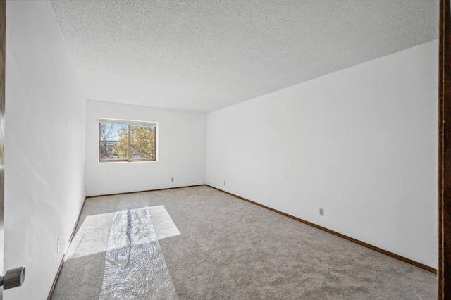 carpeted spare room with a textured ceiling