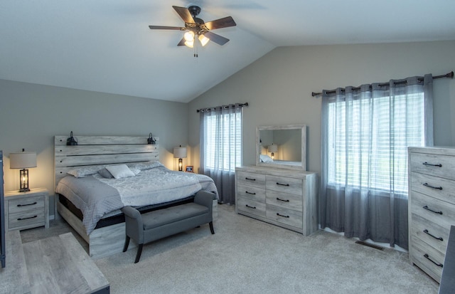 bedroom featuring ceiling fan, vaulted ceiling, and light colored carpet