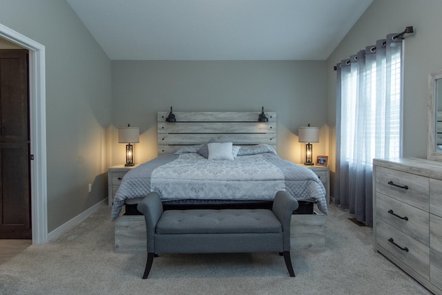 bedroom featuring light colored carpet and vaulted ceiling