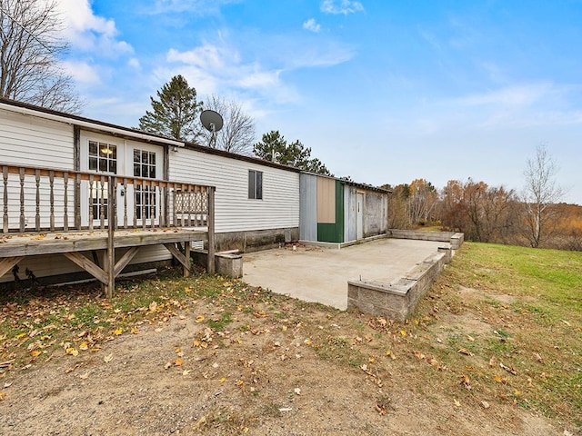 view of home's exterior featuring a wooden deck and a patio