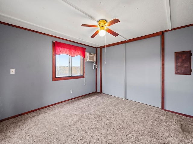 unfurnished bedroom featuring a wall mounted air conditioner, carpet floors, a closet, and ceiling fan