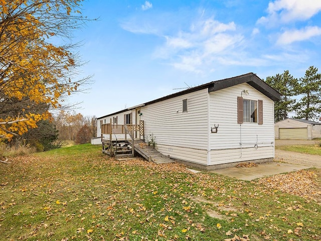 view of side of property with a yard and a deck