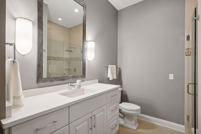 bathroom with vanity, a shower with door, and toilet