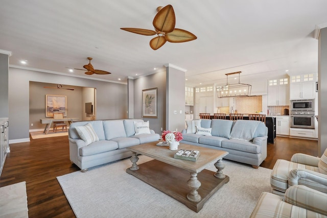 living room with crown molding, dark wood-type flooring, and ceiling fan