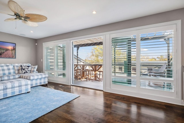 living room with dark hardwood / wood-style floors and ceiling fan