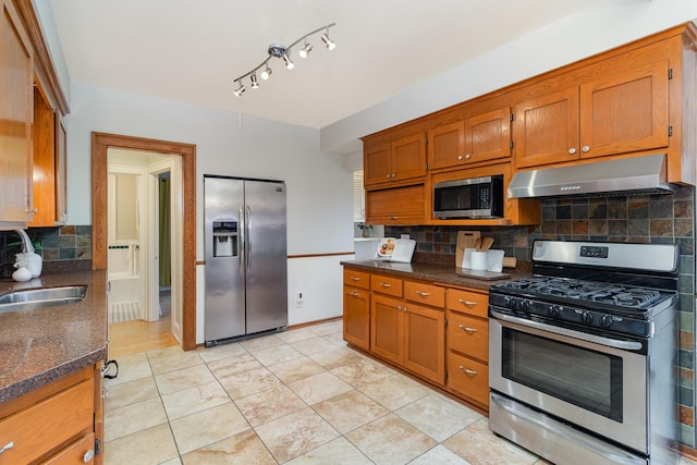 kitchen featuring decorative backsplash, sink, stainless steel appliances, and light tile patterned flooring