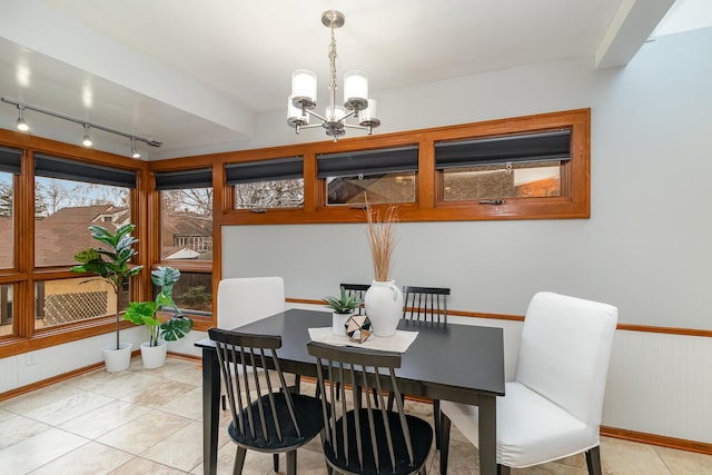 dining area featuring light tile patterned flooring, a chandelier, and track lighting