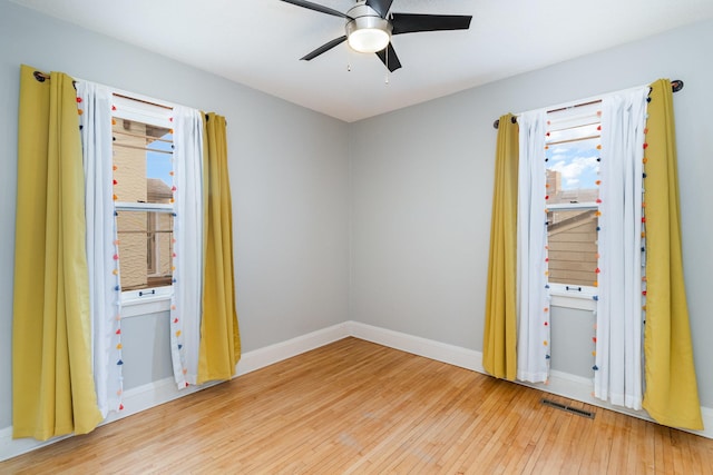 empty room with ceiling fan and hardwood / wood-style floors