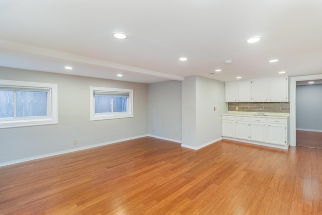 unfurnished living room with light hardwood / wood-style flooring and sink