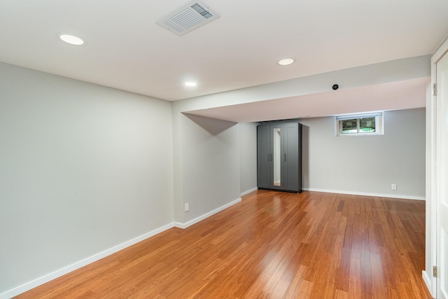 basement with hardwood / wood-style flooring