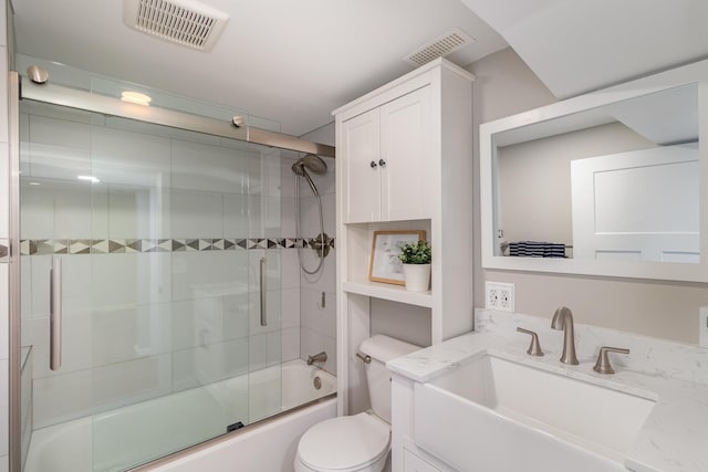 full bathroom featuring toilet, vanity, and shower / bath combination with glass door