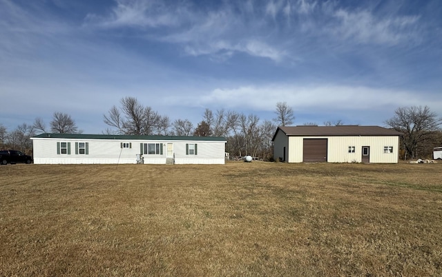 view of front of home featuring a front yard, an outdoor structure, and a garage