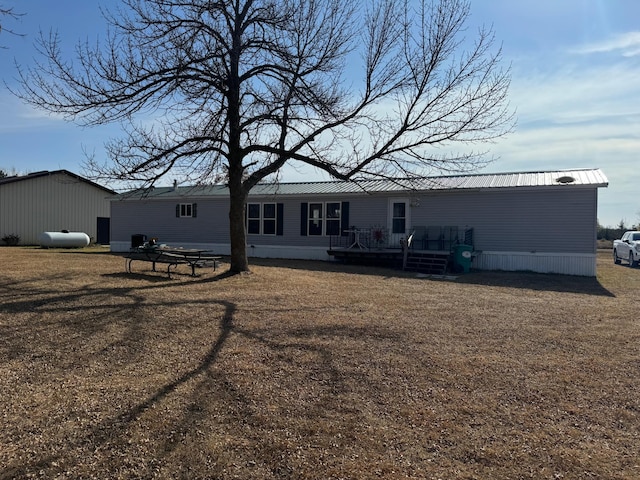 back of house with a lawn and a wooden deck