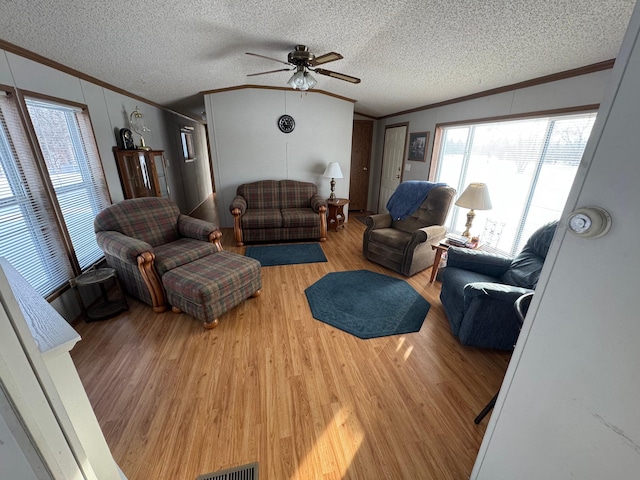 living room with ceiling fan, hardwood / wood-style floors, crown molding, and a textured ceiling