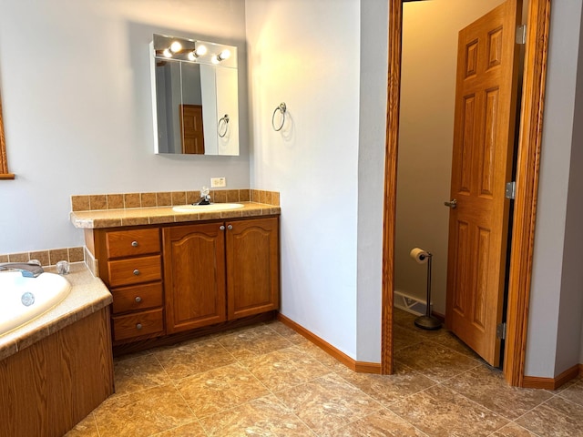 bathroom with vanity and a washtub