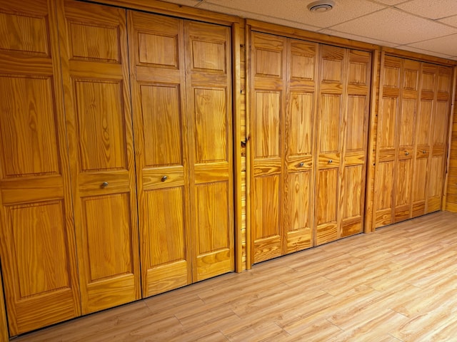 room details with a drop ceiling and hardwood / wood-style floors