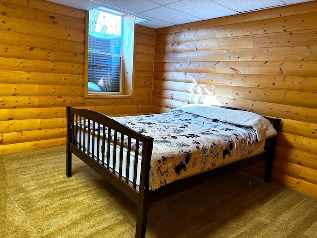 bedroom featuring rustic walls, a paneled ceiling, and carpet flooring