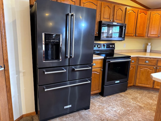 kitchen featuring high quality fridge, black electric range, and lofted ceiling