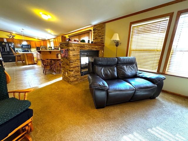 living room with a stone fireplace, lofted ceiling, ornamental molding, and carpet flooring