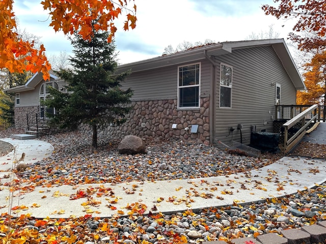 view of side of home with stone siding