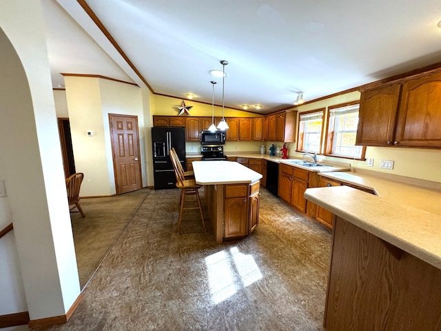 kitchen with a breakfast bar, light countertops, lofted ceiling, black appliances, and a sink