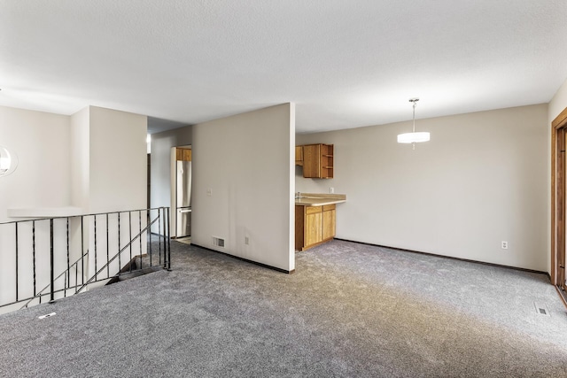 empty room featuring carpet flooring and a textured ceiling