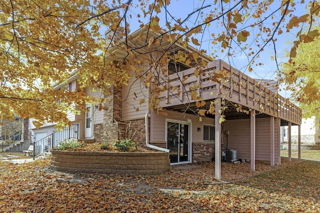 rear view of house with a wooden deck and central AC unit