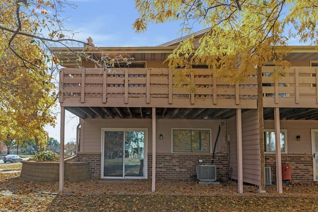 rear view of house with central AC and brick siding