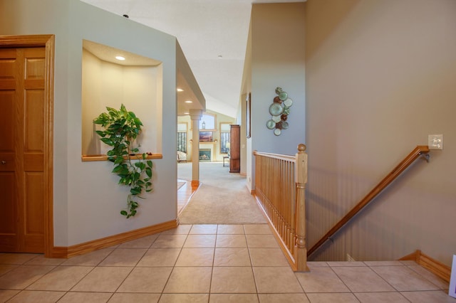 hall with decorative columns and light tile patterned floors