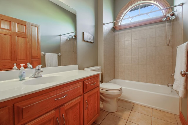 full bathroom featuring toilet, vanity, tile patterned floors, and tiled shower / bath