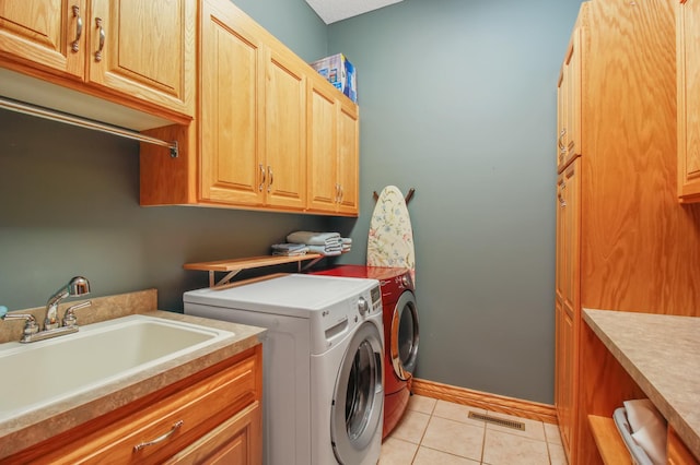 laundry room featuring cabinets, washer and clothes dryer, sink, and light tile patterned floors