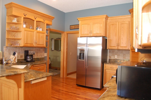 kitchen with light wood-type flooring, backsplash, stainless steel fridge with ice dispenser, a textured ceiling, and kitchen peninsula