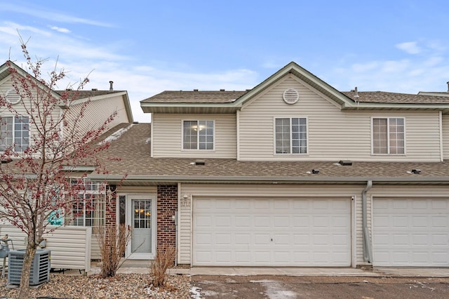 view of front of property with central air condition unit and a garage