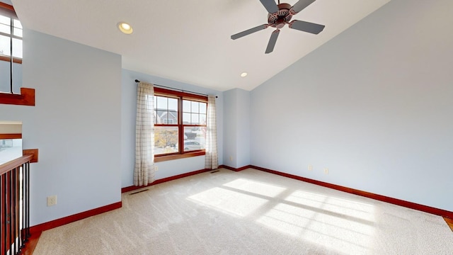 carpeted spare room featuring lofted ceiling and ceiling fan