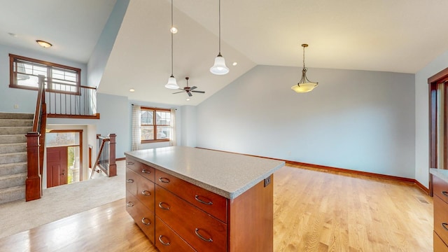 kitchen with a kitchen island, hanging light fixtures, ceiling fan, light hardwood / wood-style floors, and vaulted ceiling