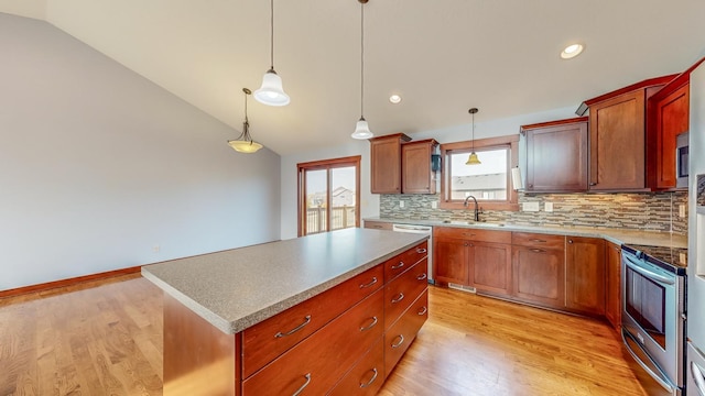 kitchen featuring light hardwood / wood-style floors, appliances with stainless steel finishes, lofted ceiling, and a kitchen island