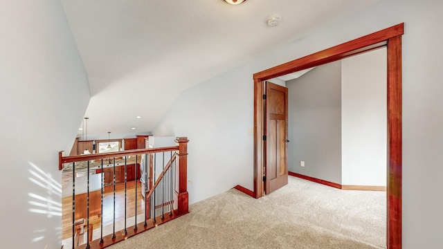 hallway with lofted ceiling and light carpet