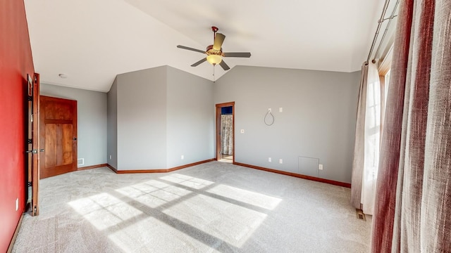 empty room featuring lofted ceiling, light colored carpet, and ceiling fan