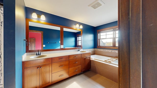 bathroom featuring vanity, tiled bath, and tile patterned floors