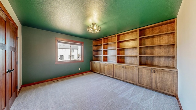 unfurnished bedroom with light carpet and a textured ceiling