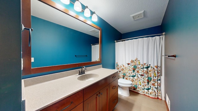 bathroom with vanity, curtained shower, a textured ceiling, and toilet